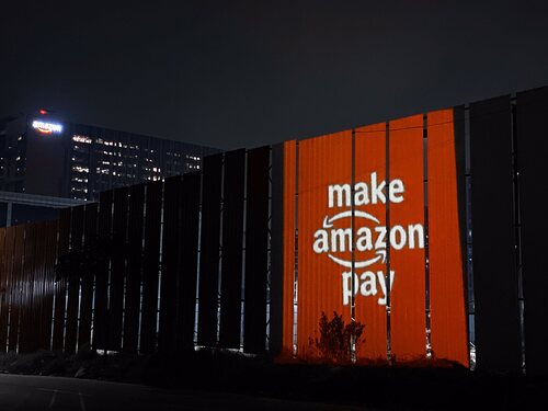 El lema 'Make Amazon Pay', proyectado al lado de una sede de Amazon en la India