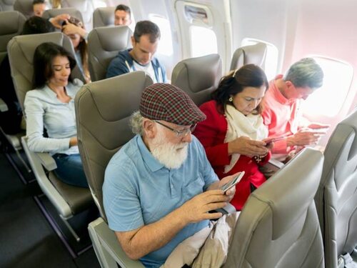 Personas usando el móvil en un avión